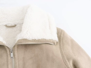 Close-up detail of khaki faux suede jacket with white shearling collar and metal zipper