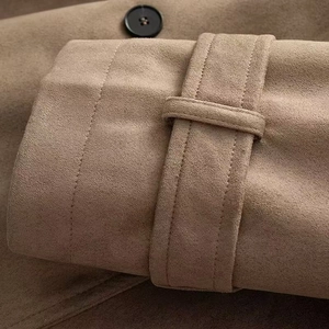 Dettaglio del polsino di un trench in pelle scamosciata color cammello con cuciture fini
