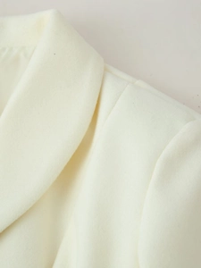 Detailed close-up of cream white wool lapel and high-quality stitching on the long coat