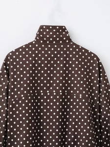 Detailansicht der Rückseite einer dunkelbraunen Polka-Dot-Jacke mit Stehkragen und Nähten