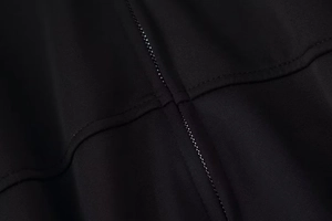 Gros plan détaillé des coutures et des ourlets renforcés sur le tissu de la veste de sport