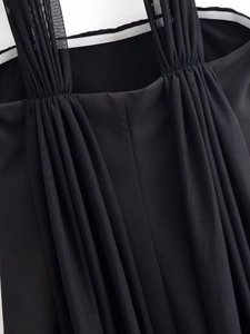 Close-up of pleated mesh straps and textured fabric on a black tube neck dress