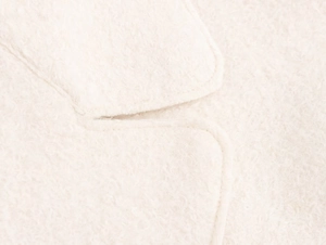 Close-up of white fleece coat collar showing detailed stitching and soft plush texture
