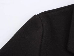 Detailed close-up of shoulder seams and thick wool fabric texture on this black coat