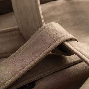 Dettaglio di borsa tote in pelle scamosciata marrone con cuciture e trama di lusso