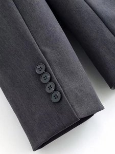 Detailed macro view of charcoal grey suit sleeve cuff with four premium black buttons