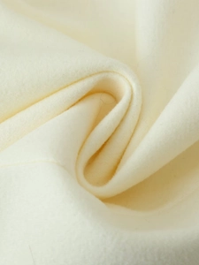 Macro shot of cream wool fabric texture showing soft fibers and premium material quality
