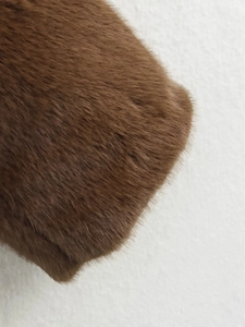 Detailed close-up showing the soft texture and fibers of a dark brown faux fur jacket