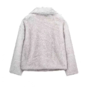 Détail de la texture pelucheuse et du col en fausse fourrure douce du manteau gris clair