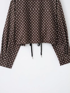 Detail der kaffeebraunen Polka-Dot-Jacke mit verstellbarem Kordelzug am Saum und Manschetten