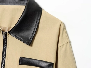 Vue détaillée de la veste en toile kaki avec col en cuir noir et fermeture éclair en métal