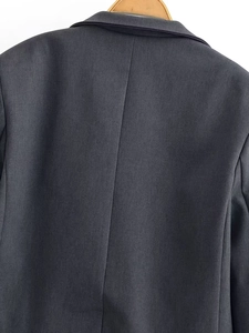 Detail view showing the neat back seam and collar structure of the dark grey suit jacket