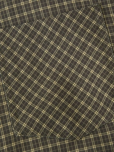 Detail of chest pocket on dark green plaid shirt with yellow grid patterns and fine stitching