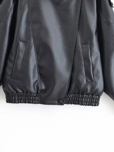 Detail of faux leather jacket hem featuring lychee texture and elastic waistband