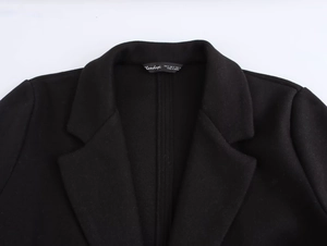 Close-up detail of the neckline and size label on a black wool blend blazer jacket