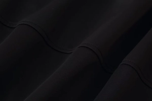 Gros plan détaillé sur un tissu noir tissé haut de gamme avec doubles coutures renforcées