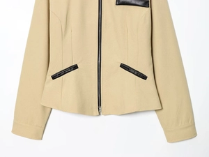 Détail d'une veste en sergé kaki avec fermeture éclair et bordures de poches en cuir noir