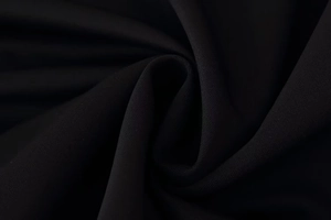 Gros plan sur un tissu textile noir avec texture tissée fine et drapé soyeux