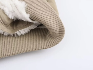 Close-up of khaki jacket with ribbed cuff and thick white faux shearling lining