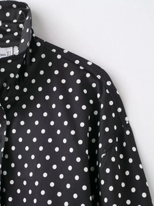 Detailaufnahme des Stehkragens und der Polka-Dot-Textur der lässigen Damenjacke
