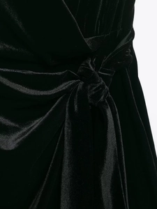 Dettaglio ravvicinato di un abito in velluto nero con nodo elegante e trama pregiata