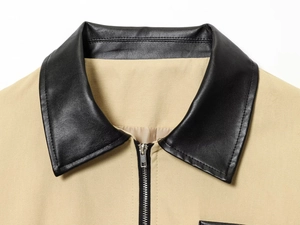 Détail du col de veste montrant le similicuir noir et le tissu en toile beige épais