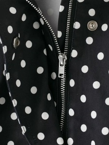 Detail von Silbermetall-Reißverschluss und Druckknöpfen an schwarzer Polka-Dot-Jacke