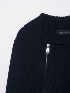Detail of navy blue ribbed knit sweater featuring a silver zipper and collar texture