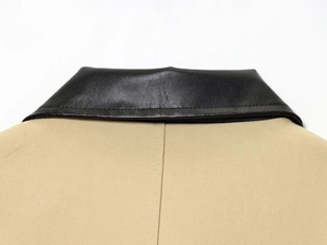 Gros plan détaillé d'une veste en toile beige avec un col en cuir noir contrastant