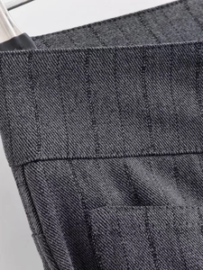 Macro shot of dark grey pinstripe fabric showing texture and neat stitching details