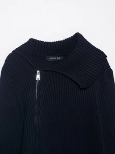 Detail of navy blue ribbed knit cardigan featuring asymmetrical silver metal zipper close-up