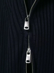 Detail of navy ribbed knit fabric featuring a premium silver two-way metal zipper closure