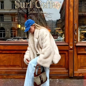 Manteau chic en fausse fourrure crème avec casquette bleue et jean large