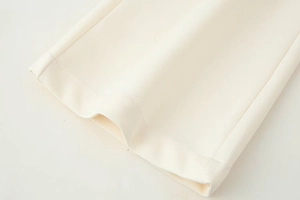 Gros plan du tissu sergé crème et des détails de couture précise à double aiguille