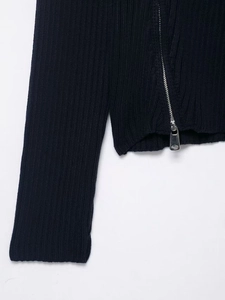 Detail of ribbed knit fabric texture and high-quality silver metal zipper on navy jacket