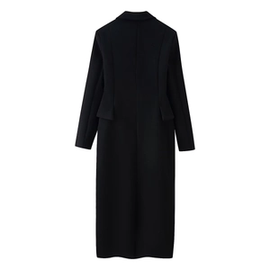 Detail view of tailored back seams and pocket flaps on a long black wool coat