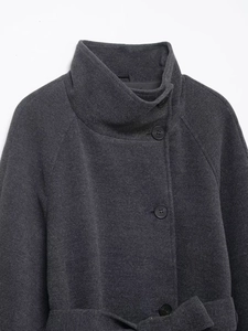 Detail of high stand collar and wool texture on dark grey autumn coat with buttons
