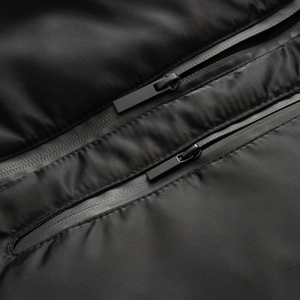 Close-up of urban functional jacket featuring waterproof zippers and matte black fabric