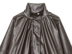 Detail of dark brown faux leather bomber jacket with high stand collar and silver snaps
