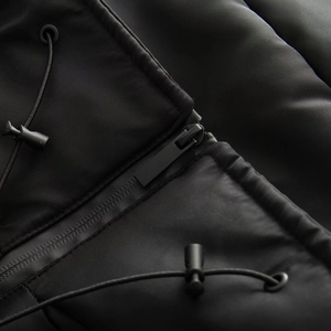 Detail of black waterproof fabric with matte zipper and adjustable drawstring on hooded parka