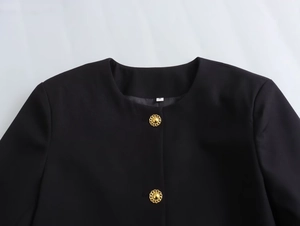 Detail of black round neck short jacket featuring gold textured buttons and size S tag