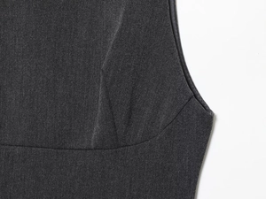 Détail macro de la mini-robe grise à volants montrant la couture précise de l'emmanchure