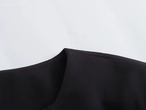 Detailed close-up showing the premium stitching and matte fabric of the black jacket
