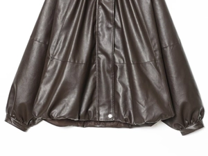 Detail of faux leather bomber jacket showing ruched texture and bubble hem with snap button