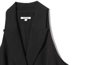 Detail of a black sleeveless blazer vest with notch lapel and white size S neck label
