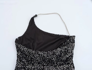 Detail view of black sequin one-shoulder dress with a thin silver chain strap