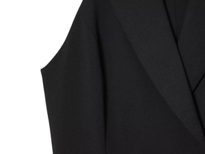 Close-up of black twill fabric texture and lapel tailoring on the blazer dress
