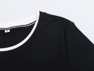 Détail de la couture contrastée du col et de la texture douce en maille côtelée du haut