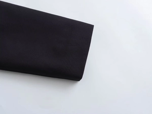 Detail of high-density black woven fabric with smooth texture and clean edges on the jacket