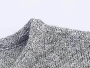 Close-up of the premium grey knit texture and seamless shoulder stitching on the coat